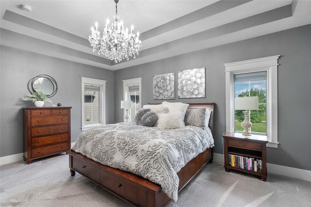 bedroom featuring light carpet, a chandelier, baseboards, and a raised ceiling