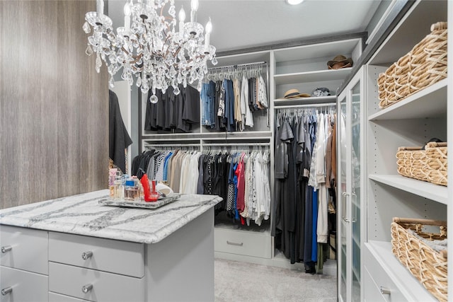 walk in closet with a chandelier and carpet