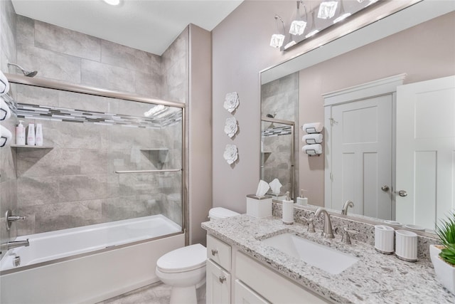 full bathroom with combined bath / shower with glass door, toilet, and vanity