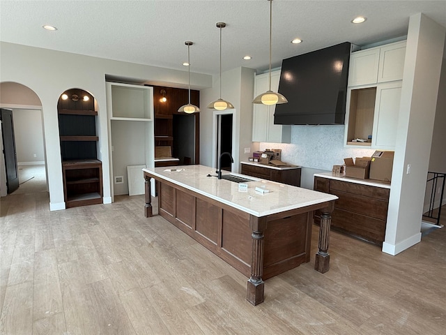 1128 NW 29th Ct, Grimes, IA 50111 - kitchen with a sink, light wood finished floors, a large island with sink, white cabinetry, and baseboards