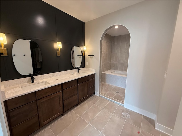 1128 NW 29th Ct, Grimes, IA 50111 - full bathroom with tile patterned floors, double vanity, baseboards, and a bath