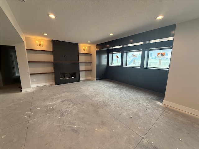 1128 NW 29th Ct, Grimes, IA 50111 - unfurnished living room with a textured ceiling, a fireplace, recessed lighting, built in features, and baseboards
