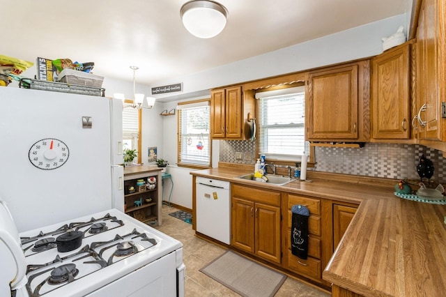 2322 E 39th St, Des Moines, IA 50317 - kitchen with white appliances, brown cabinetry, and backsplash