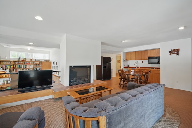 6252 Panorama Dr, Panora, IA 50216 - living area featuring light carpet, a glass covered fireplace, and recessed lighting