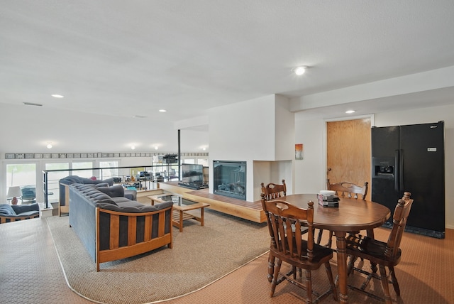 6252 Panorama Dr, Panora, IA 50216 - living area featuring a glass covered fireplace, recessed lighting, and light carpet