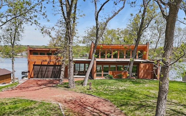 6252 Panorama Dr, Panora, IA 50216 - view of front of house featuring dirt driveway, a water view, a front lawn, and a garage
