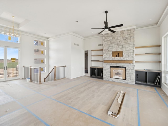 17406 Oakwood Dr, Urbandale, IA 50322 - unfurnished living room with ceiling fan, crown molding, a stone fireplace, and a chandelier