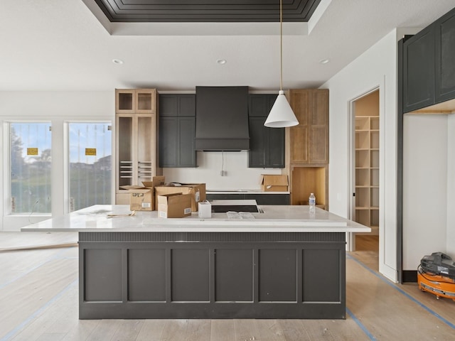 17406 Oakwood Dr, Urbandale, IA 50322 - kitchen with custom exhaust hood, a center island, light countertops, hanging light fixtures, and a tray ceiling