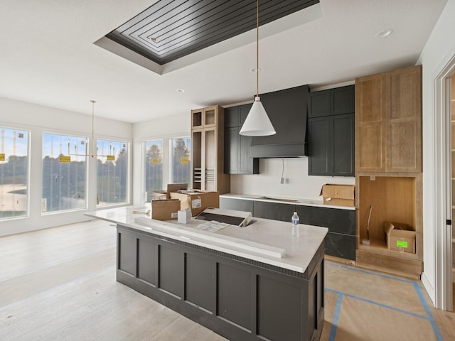 17406 Oakwood Dr, Urbandale, IA 50322 - kitchen featuring premium range hood, light wood-style floors, decorative light fixtures, a center island, and a chandelier