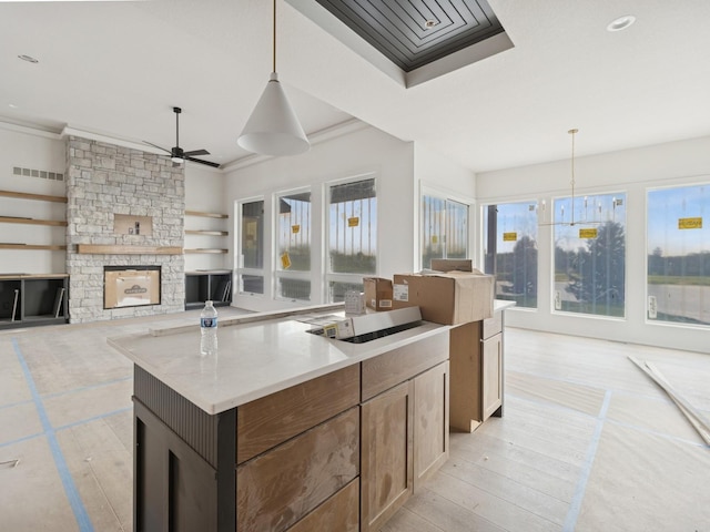 17406 Oakwood Dr, Urbandale, IA 50322 - kitchen with a ceiling fan, a stone fireplace, decorative light fixtures, a center island, and recessed lighting