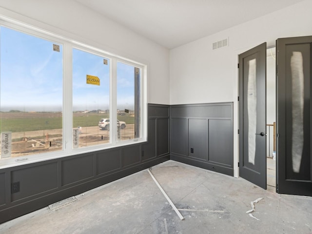 17406 Oakwood Dr, Urbandale, IA 50322 - unfurnished room featuring a decorative wall and wainscoting