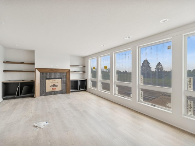 17406 Oakwood Dr, Urbandale, IA 50322 - unfurnished living room featuring healthy amount of natural light, a fireplace, and wood finished floors
