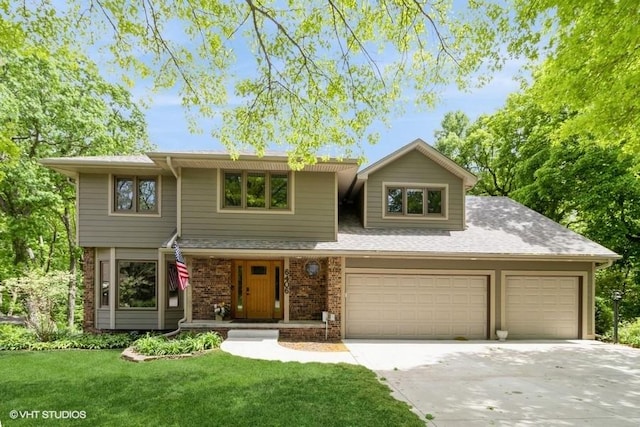 6406 Theresa Dr, Johnston, IA 50131 - view of front of home with driveway, a front lawn, an attached garage, and brick siding