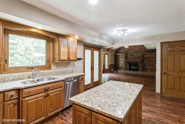 6406 Theresa Dr, Johnston, IA 50131 - kitchen with stainless steel dishwasher, a sink, a textured ceiling, dark wood finished floors, and brown cabinets