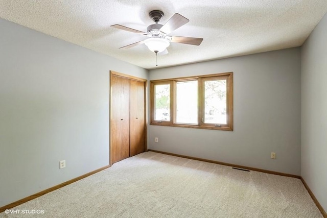 6406 Theresa Dr, Johnston, IA 50131 - unfurnished bedroom featuring carpet floors, a closet, baseboards, a textured ceiling, and ceiling fan