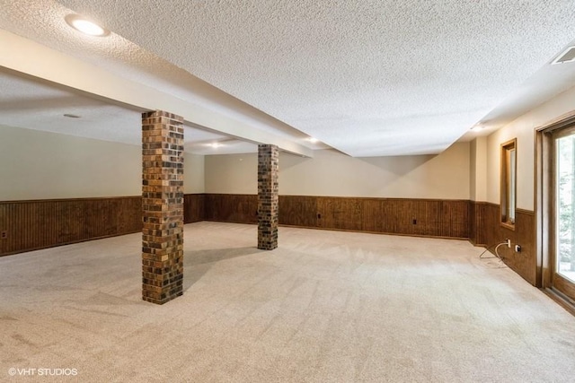 6406 Theresa Dr, Johnston, IA 50131 - basement featuring a wainscoted wall, wood walls, a textured ceiling, and carpet