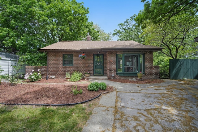 1919 Arlington Ave, Des Moines, IA 50314 - view of front of house with brick siding, fence, a chimney, and roof with shingles