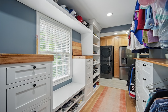 1919 Arlington Ave, Des Moines, IA 50314 - walk in closet featuring estacked washer and dryer and light wood finished floors
