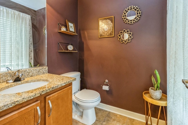 half bath featuring toilet, baseboards, tile patterned flooring, and vanity