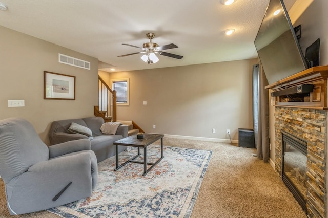 living area with carpet flooring, ceiling fan, stairway, a fireplace, and baseboards