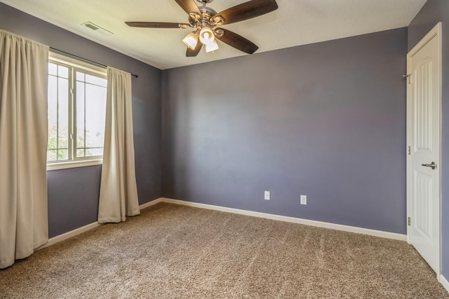 spare room featuring carpet, a ceiling fan, and baseboards