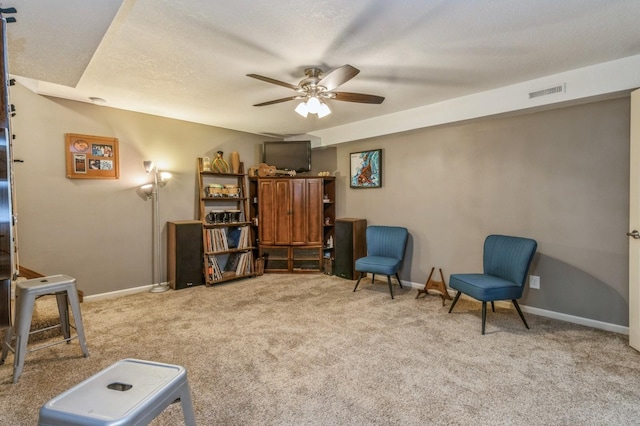 sitting room with carpet flooring, a ceiling fan, and baseboards