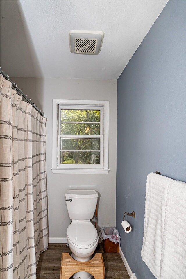 4014 Aplin Rd, Ames, IA 50014 - full bathroom featuring wood finished floors, toilet, baseboards, and a shower with shower curtain