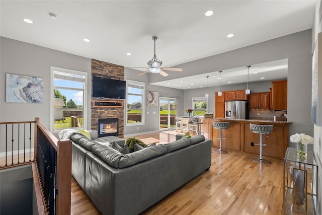 913 SE Trail Ridge Rd, Grimes, IA 50111 - living room with recessed lighting, light wood-style floors, ceiling fan, a fireplace, and plenty of natural light