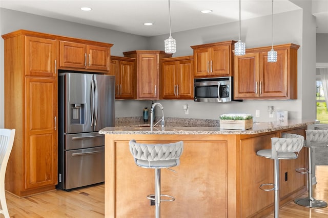 913 SE Trail Ridge Rd, Grimes, IA 50111 - kitchen featuring appliances with stainless steel finishes, light wood-style flooring, a kitchen breakfast bar, and recessed lighting