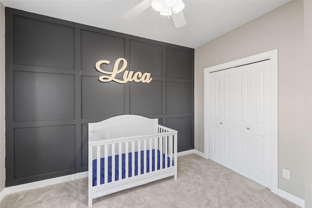 913 SE Trail Ridge Rd, Grimes, IA 50111 - carpeted bedroom featuring a decorative wall, a closet, a nursery area, baseboards, and ceiling fan