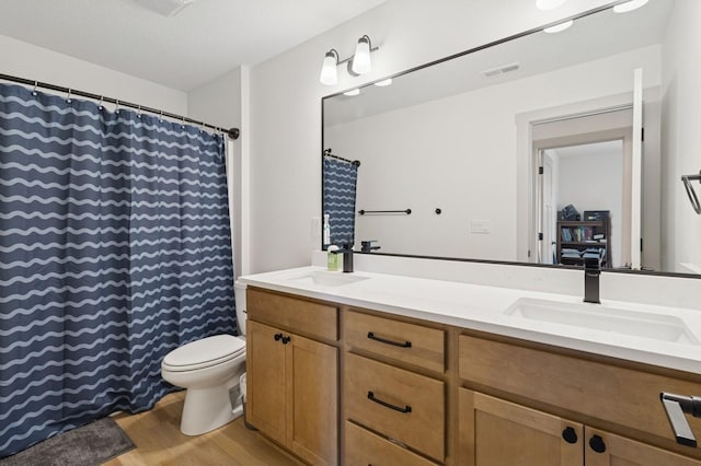585 NW Rosemont Dr, Waukee, IA 50263 - full bathroom with double vanity, wood finished floors, and a shower with shower curtain