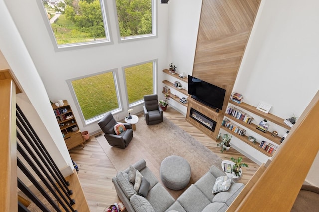 585 NW Rosemont Dr, Waukee, IA 50263 - living area featuring a fireplace, a high ceiling, and wood finished floors