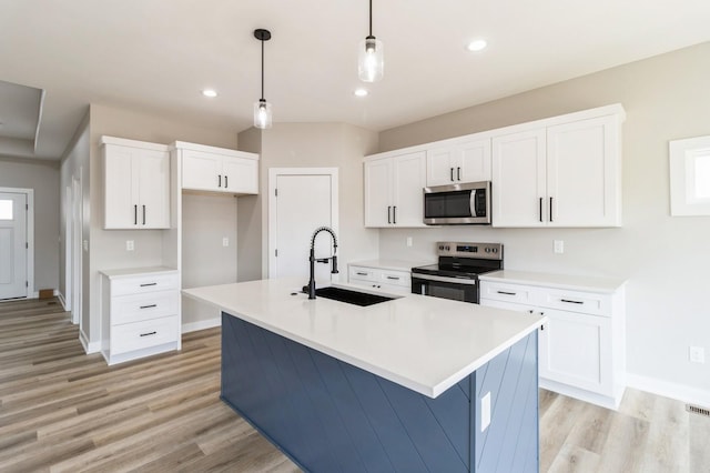 14512 Northpark Dr, Urbandale, IA 50111 - kitchen featuring appliances with stainless steel finishes, a sink, light wood finished floors, white cabinets, and recessed lighting