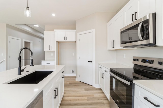 14512 Northpark Dr, Urbandale, IA 50111 - kitchen featuring appliances with stainless steel finishes, a sink, light wood-style flooring, white cabinets, and light countertops