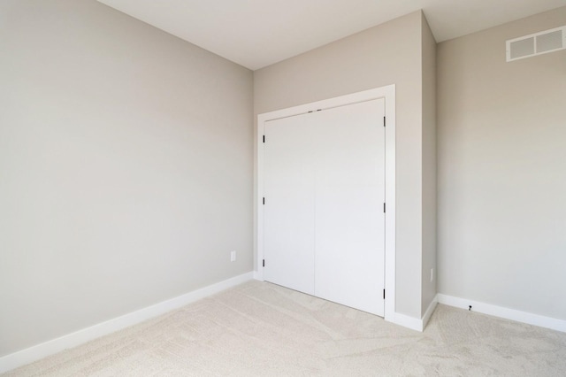 14512 Northpark Dr, Urbandale, IA 50111 - unfurnished bedroom with light colored carpet, baseboards, and a closet