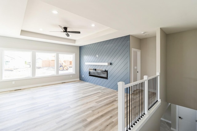14512 Northpark Dr, Urbandale, IA 50111 - unfurnished living room featuring wood finished floors, a tray ceiling, a ceiling fan, baseboards, and recessed lighting