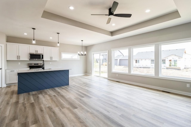14512 Northpark Dr, Urbandale, IA 50111 - kitchen with appliances with stainless steel finishes, a chandelier, white cabinets, baseboards, and light countertops