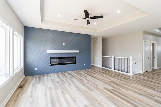 14512 Northpark Dr, Urbandale, IA 50111 - unfurnished living room with a tray ceiling, a ceiling fan, wood finished floors, a fireplace, and recessed lighting