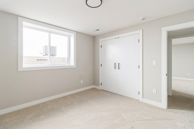 14512 Northpark Dr, Urbandale, IA 50111 - unfurnished bedroom with light carpet, baseboards, and a closet