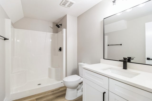 14512 Northpark Dr, Urbandale, IA 50111 - full bath with wood finished floors, a shower, toilet, vanity, and vaulted ceiling