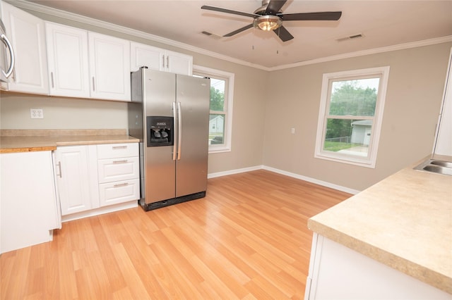 101 E Cronkhite St, Knoxville, IA 50138 - kitchen featuring stainless steel fridge with ice dispenser, light wood finished floors, white cabinets, a ceiling fan, and ornamental molding