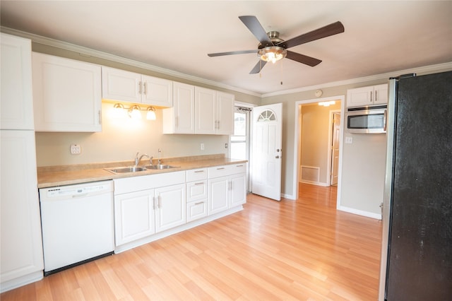 101 E Cronkhite St, Knoxville, IA 50138 - kitchen featuring appliances with stainless steel finishes, a sink, white cabinets, ceiling fan, and ornamental molding