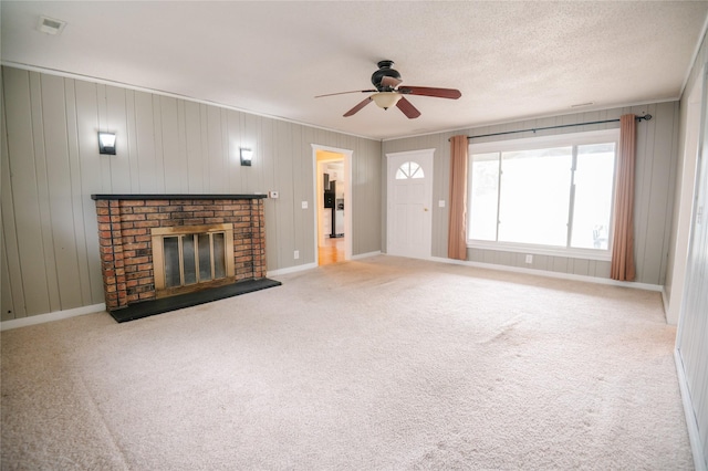 101 E Cronkhite St, Knoxville, IA 50138 - unfurnished living room with a ceiling fan, a brick fireplace, and carpet flooring