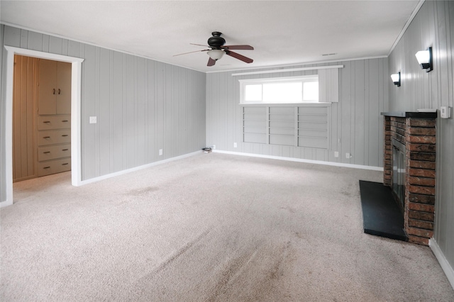 101 E Cronkhite St, Knoxville, IA 50138 - unfurnished living room with a fireplace, crown molding, baseboards, a ceiling fan, and carpet flooring