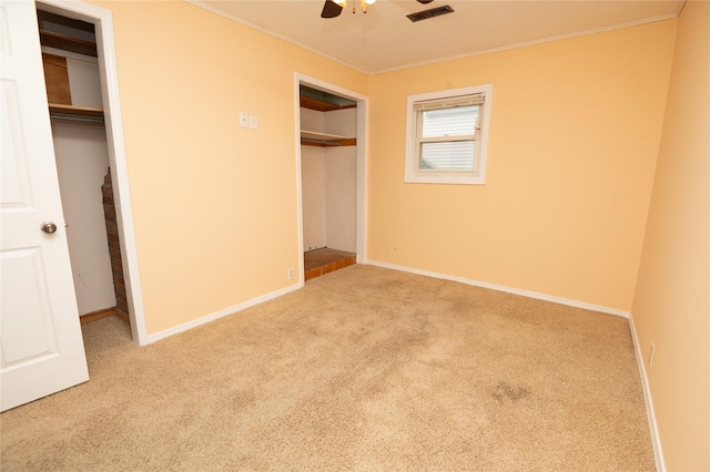 101 E Cronkhite St, Knoxville, IA 50138 - unfurnished bedroom with carpet floors, crown molding, two closets, and baseboards