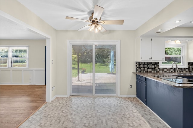6700 Sheridan Ave, Des Moines, IA 50322 - kitchen with black electric stovetop, plenty of natural light, decorative backsplash, white cabinetry, and recessed lighting