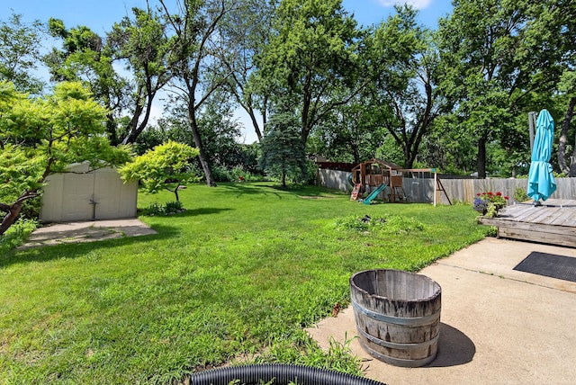 6700 Sheridan Ave, Des Moines, IA 50322 - fenced backyard with a playground, a storage unit, and a deck