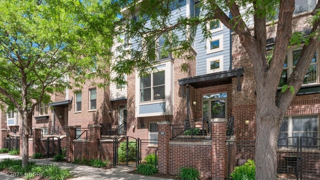 201 Grand Ave Unit 109, Des Moines, IA 50309 - view of property with a gate, brick siding, and fence