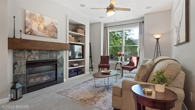 201 Grand Ave Unit 109, Des Moines, IA 50309 - carpeted living area with a tile fireplace, built in features, baseboards, and ceiling fan