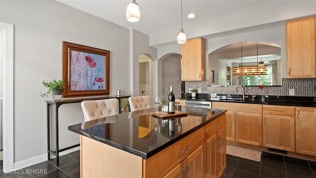 201 Grand Ave Unit 109, Des Moines, IA 50309 - kitchen featuring a sink, dark countertops, backsplash, light brown cabinetry, and dark tile patterned flooring